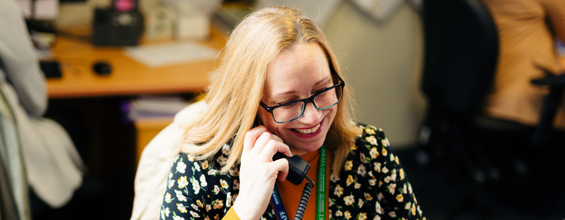 Student Services staff smiling whilst on telephone