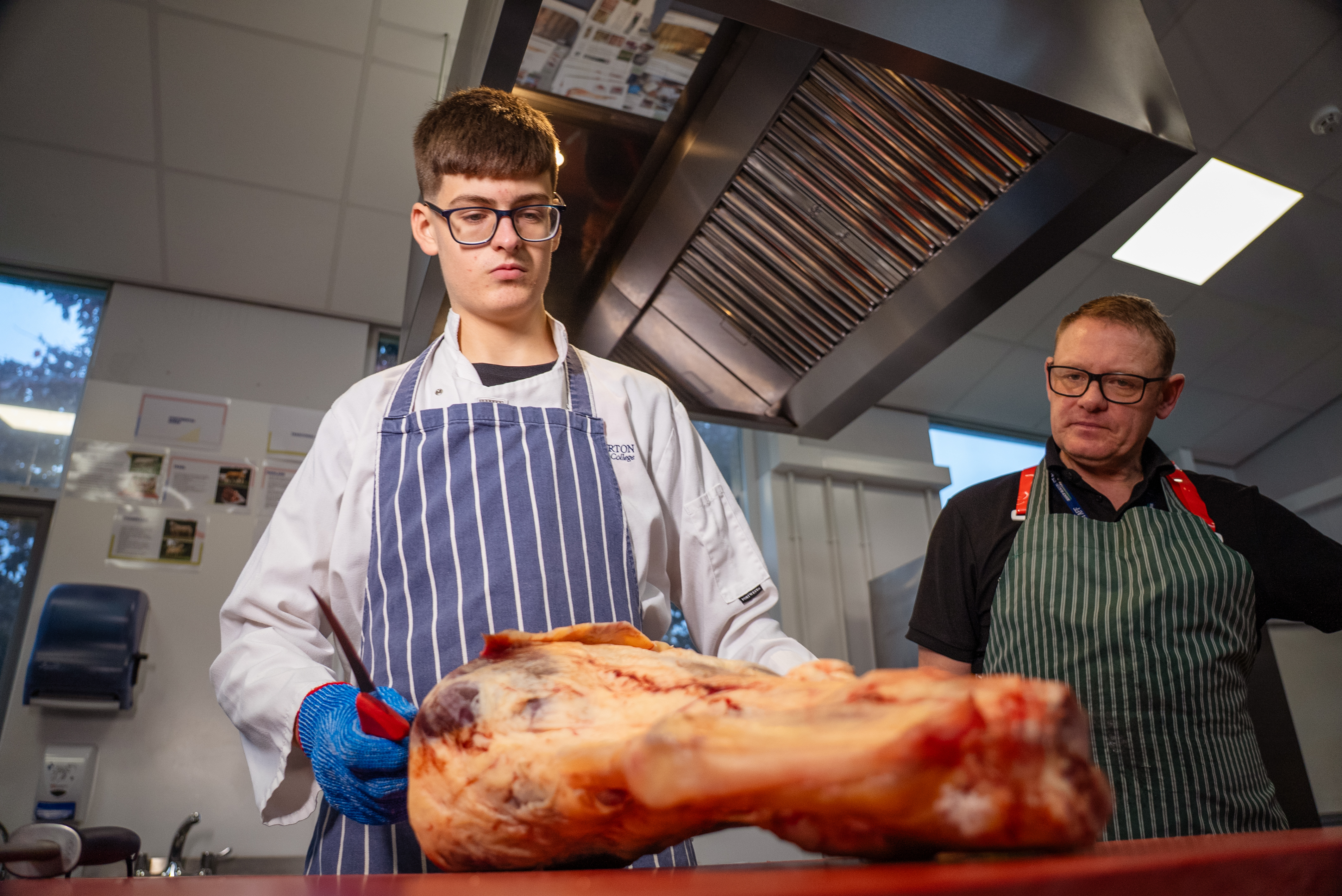 Apprentice and teacher about to work on meat