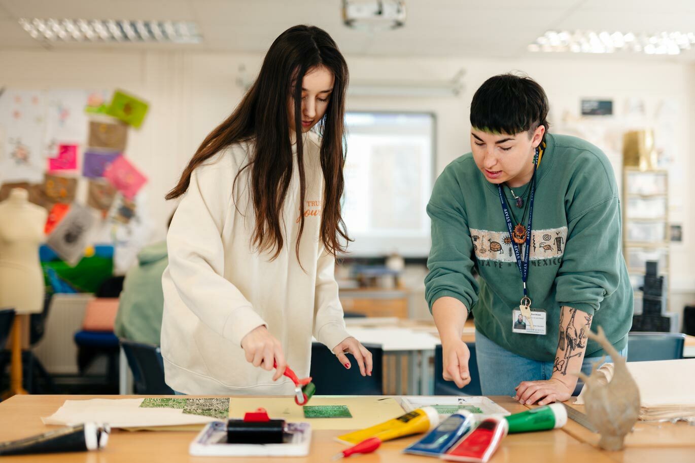 Art and design student learning to lino print with tutor