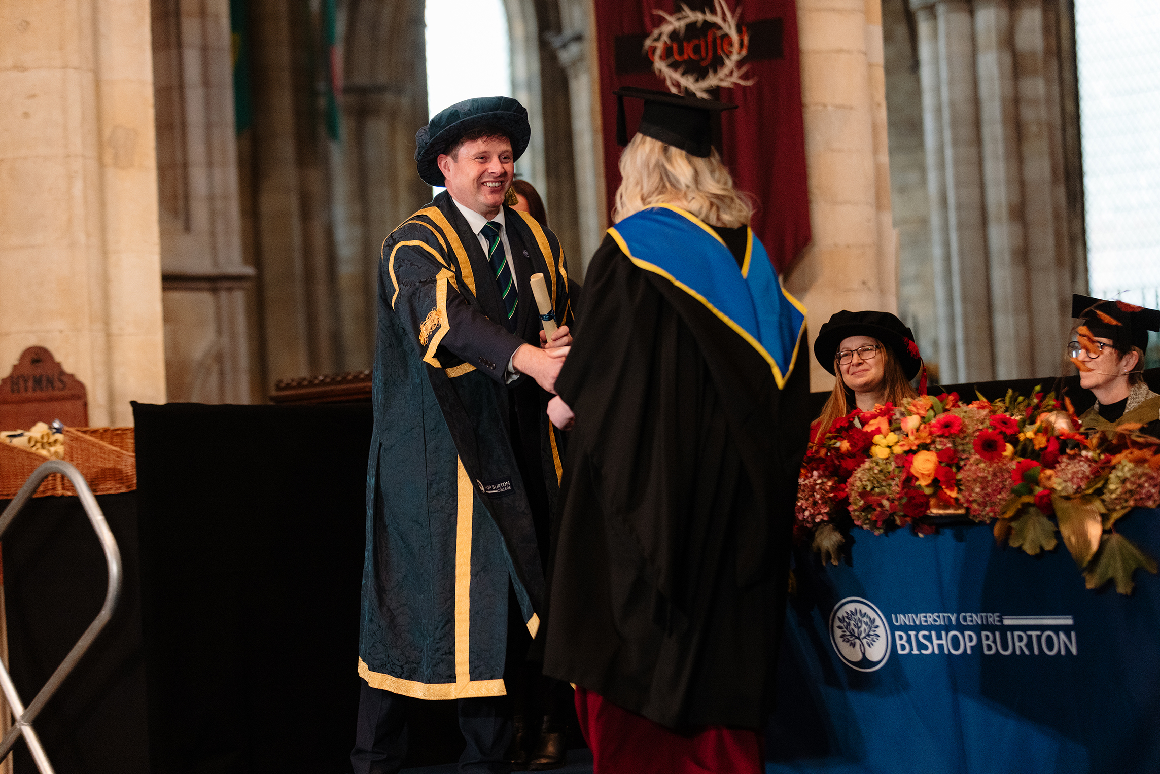 Bishop Burton College Principal Danny Metters shaking hands with a graduating student