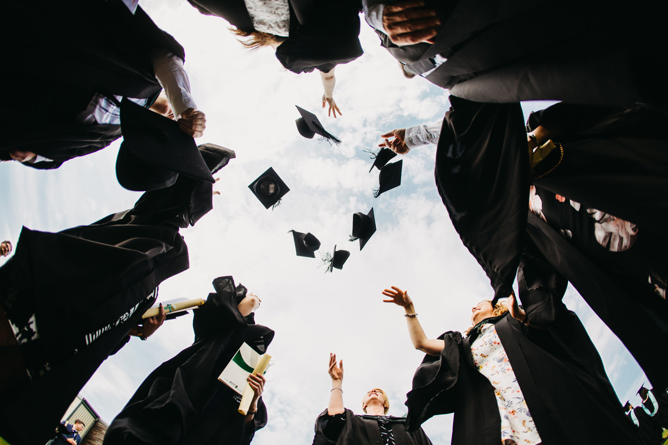 International image Graduates throwing caps into the air