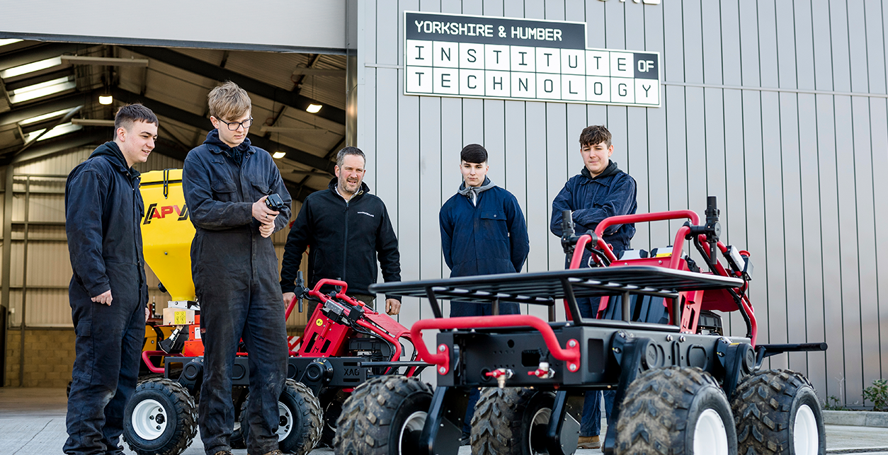 Io T students working on robot equipment outside the workshop