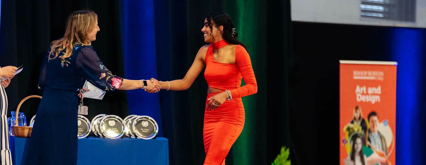 Student shaking hands across the stage