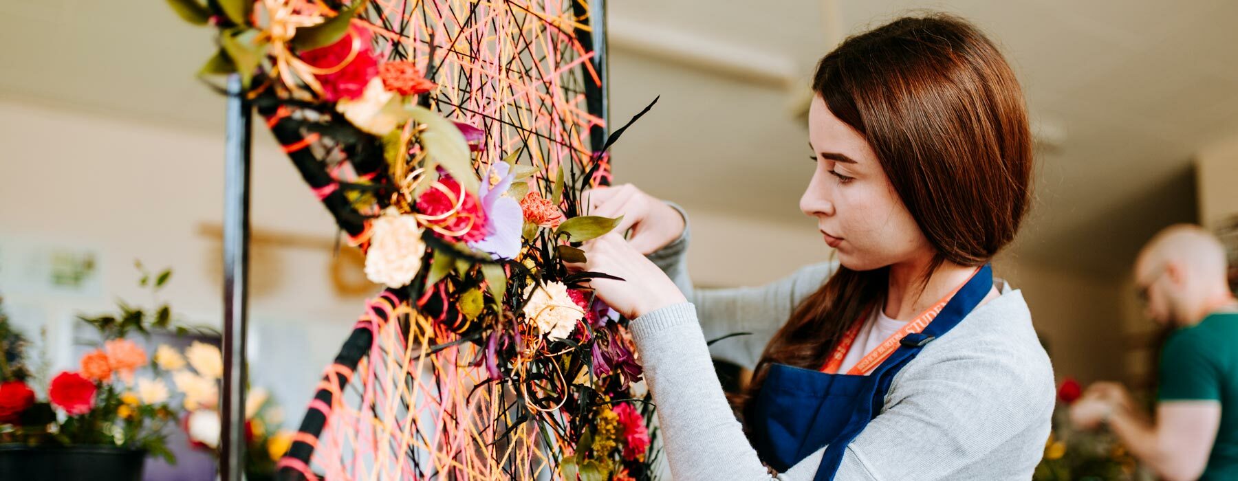 Student working on large floral installation