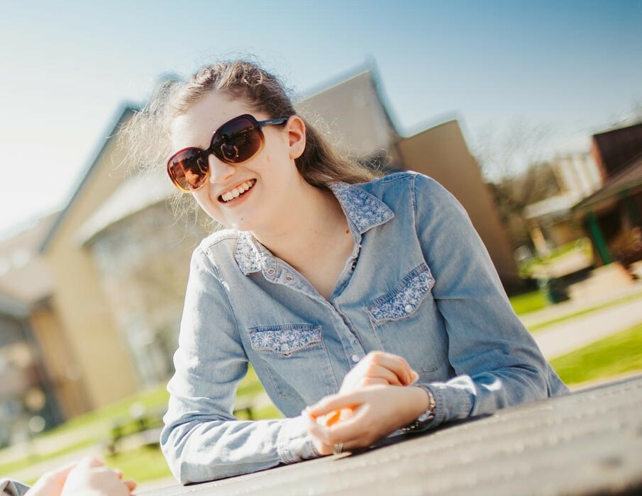 Students sat at picnic bench smiling thumb