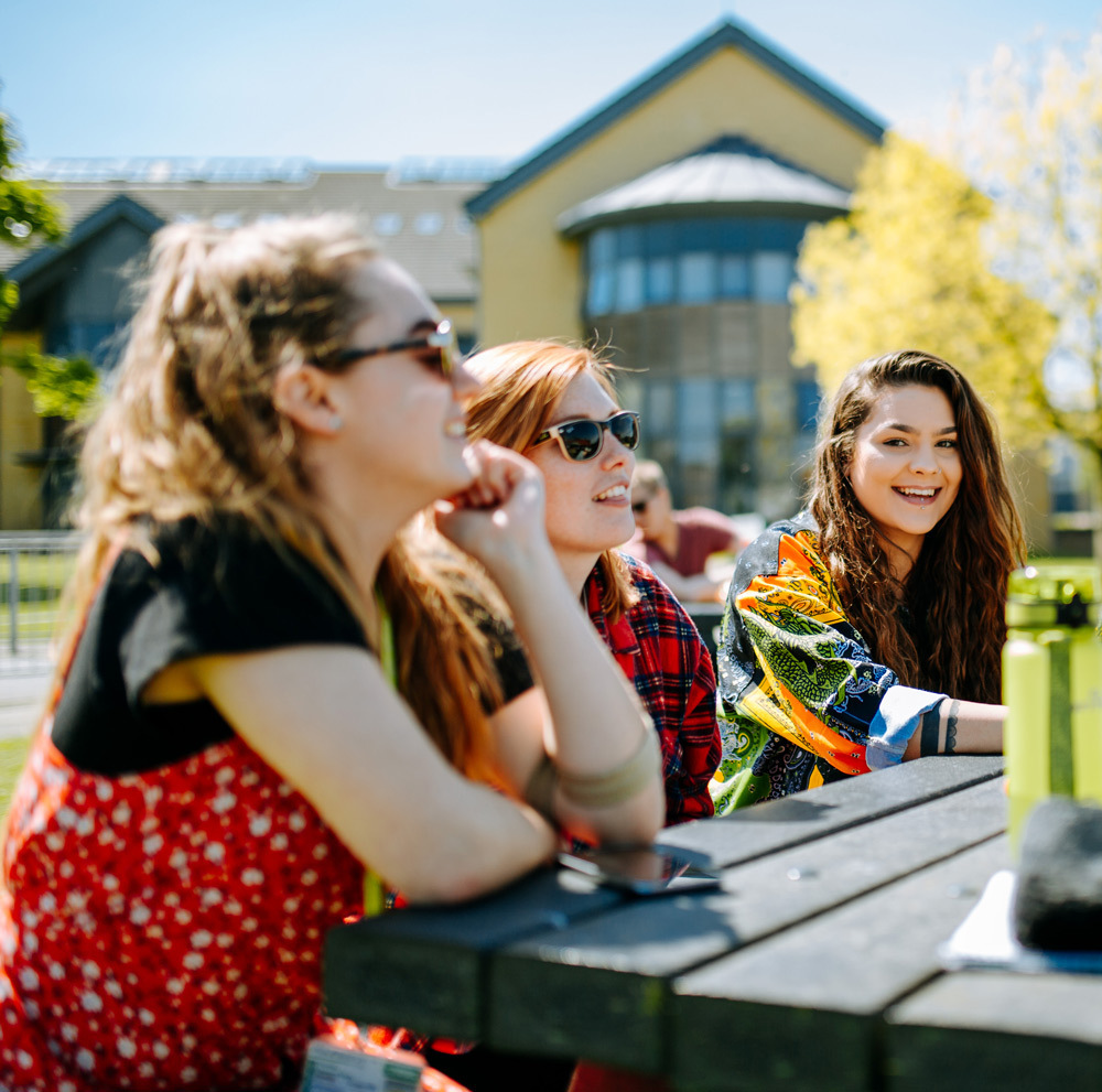 Students sat at picnic bench thumb